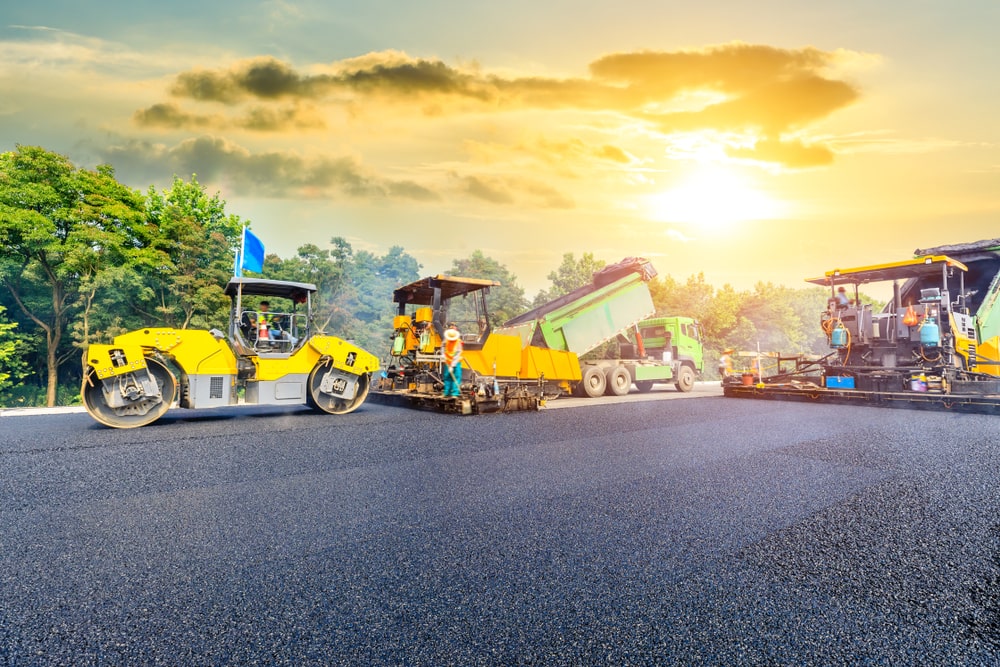 asphalt contractors working with beautiful sunset in the background