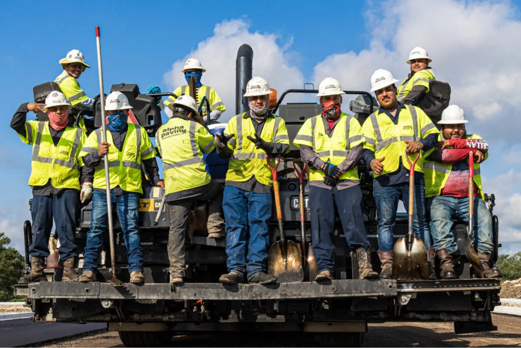 Standard Paving asphalt crew standing on paving machine during road construction project in Annapolis or Baltimore Maryland