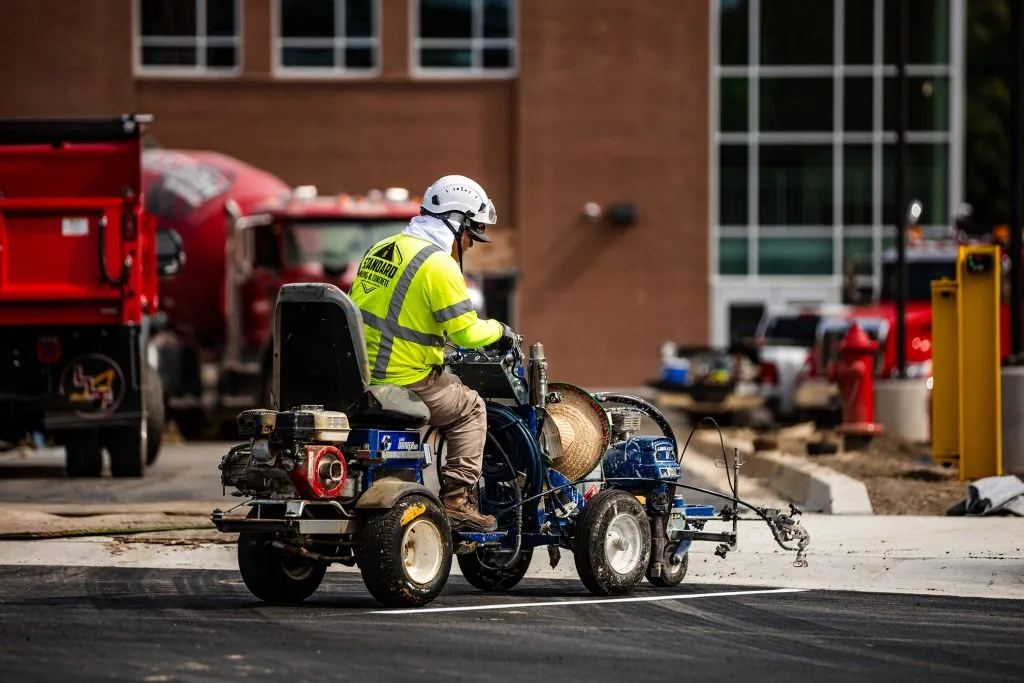 A man driving a small paving machine