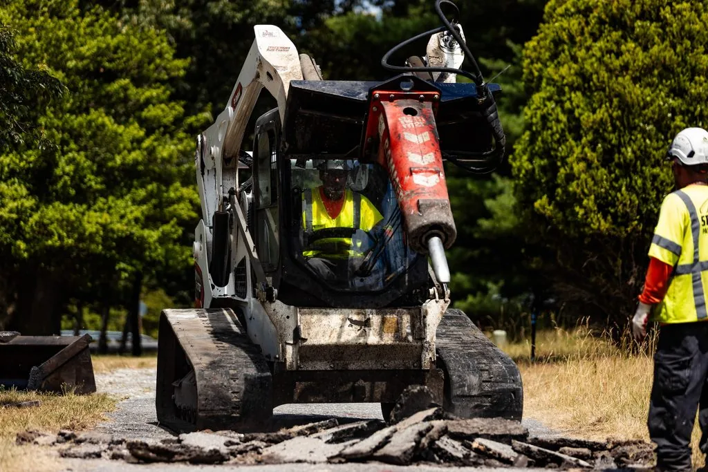 a construction vehicle with a man driving on the side