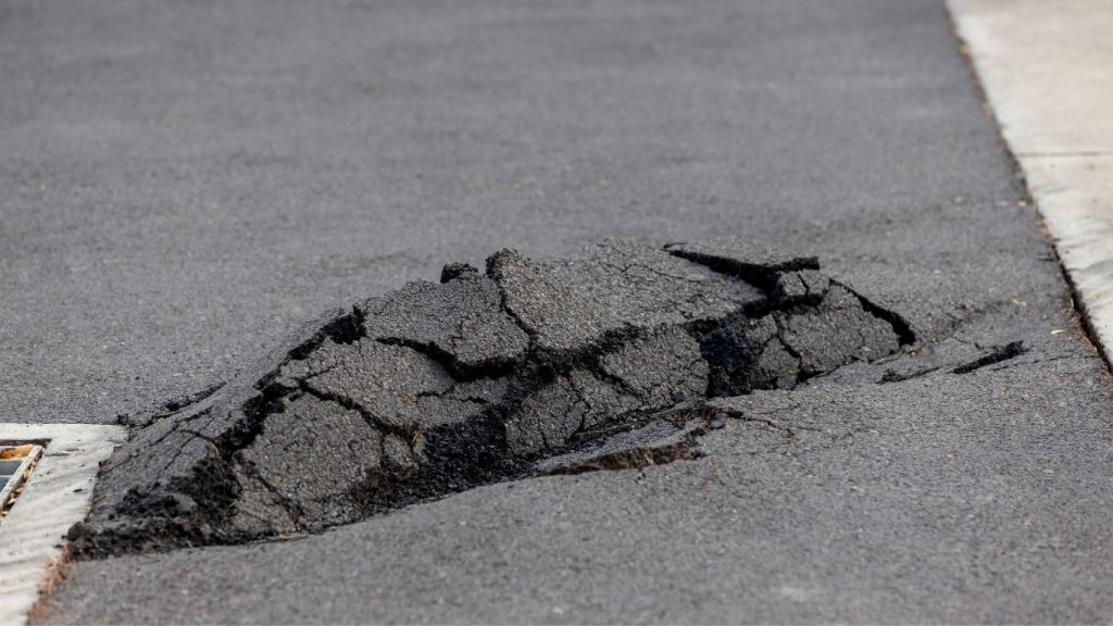 damaged asphalt that appears to have been upheaved